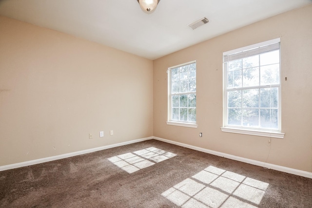 carpeted empty room with visible vents and baseboards