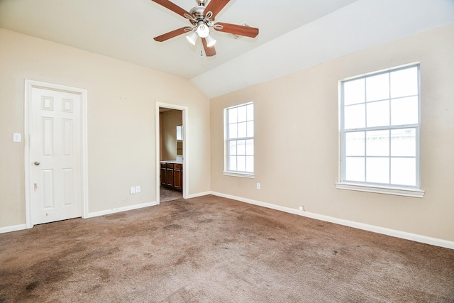 unfurnished room featuring a ceiling fan, carpet flooring, vaulted ceiling, and baseboards