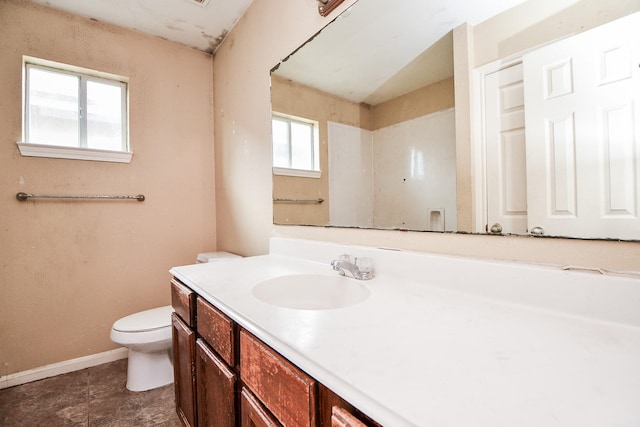 bathroom with toilet, baseboards, and vanity