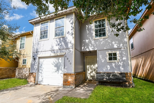 view of front facade with a garage, driveway, and stucco siding