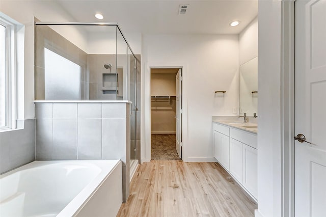 bathroom with vanity, hardwood / wood-style floors, and separate shower and tub