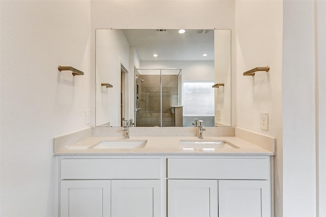 bathroom with vanity and a shower with door