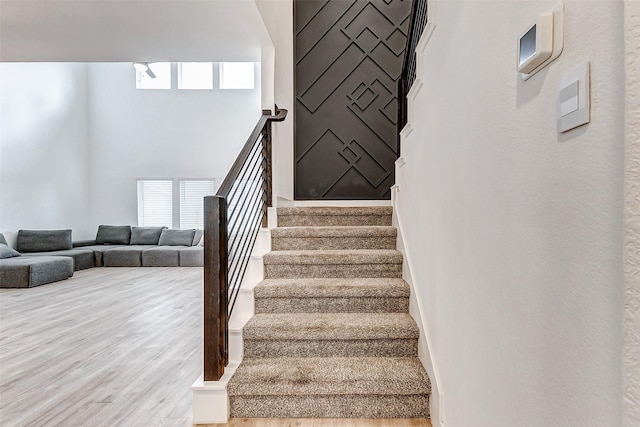 stairway featuring a healthy amount of sunlight and hardwood / wood-style floors