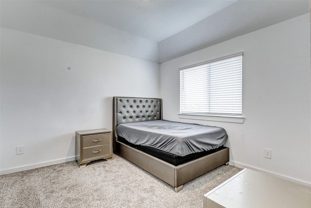 bedroom with light carpet and vaulted ceiling