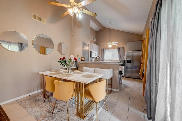 dining space featuring light tile patterned flooring, ceiling fan, and high vaulted ceiling