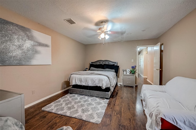 bedroom featuring dark hardwood / wood-style flooring, ceiling fan, and a textured ceiling