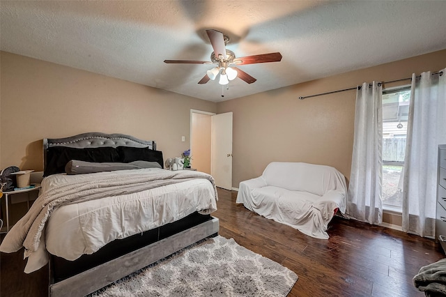 bedroom with ceiling fan, dark hardwood / wood-style floors, and a textured ceiling