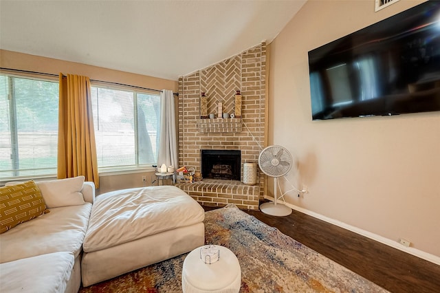 living room featuring a fireplace, vaulted ceiling, and wood-type flooring