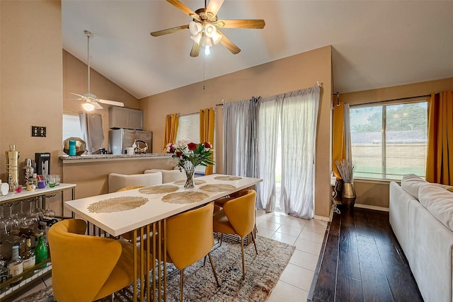 tiled dining room with vaulted ceiling and ceiling fan