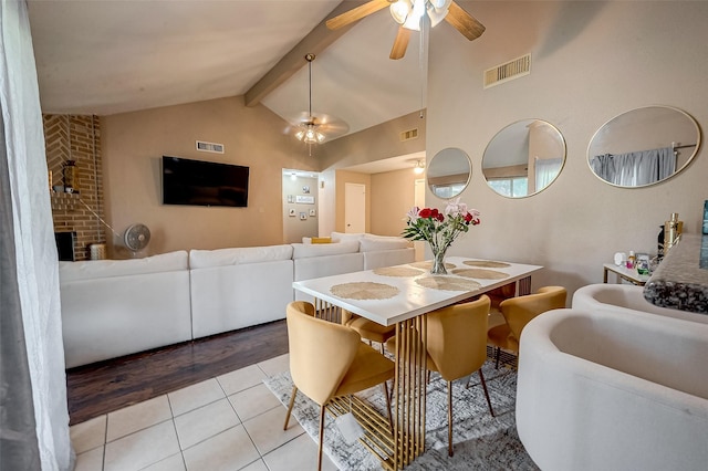 dining area with ceiling fan, high vaulted ceiling, light tile patterned floors, and beam ceiling