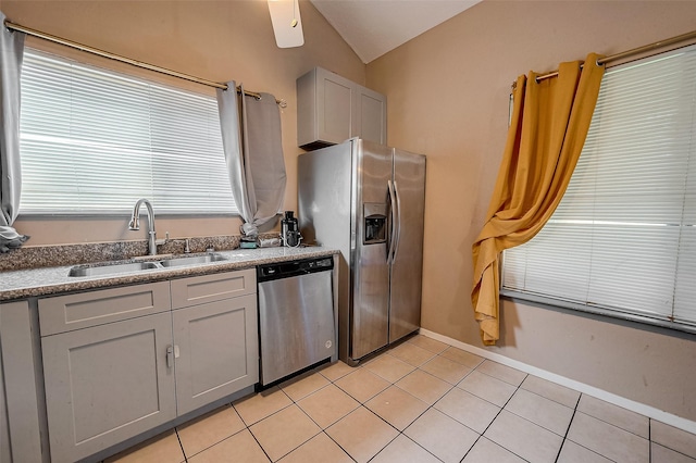 kitchen featuring light tile patterned flooring, sink, gray cabinetry, vaulted ceiling, and stainless steel appliances