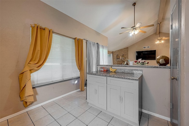 kitchen featuring light tile patterned flooring, lofted ceiling, white cabinetry, dark stone countertops, and ceiling fan