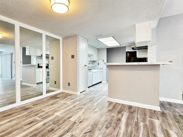 kitchen featuring light hardwood / wood-style flooring, white dishwasher, range with electric stovetop, white cabinets, and kitchen peninsula