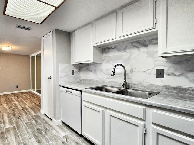 kitchen featuring dishwasher, sink, decorative backsplash, and white cabinets