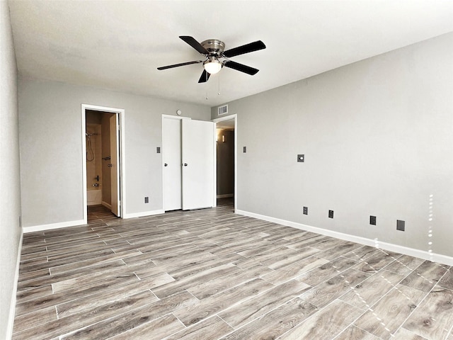 unfurnished bedroom featuring ensuite bathroom, ceiling fan, and light wood-type flooring