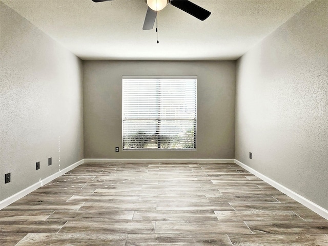 spare room with ceiling fan, light hardwood / wood-style floors, and a textured ceiling