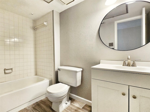 full bathroom featuring vanity, tiled shower / bath, and toilet