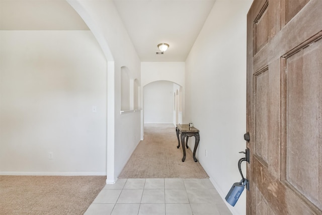 corridor featuring light colored carpet