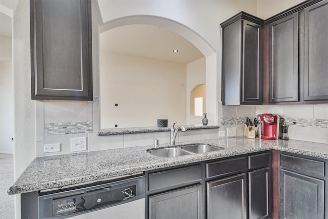 kitchen with tasteful backsplash, sink, dark brown cabinets, and stainless steel dishwasher