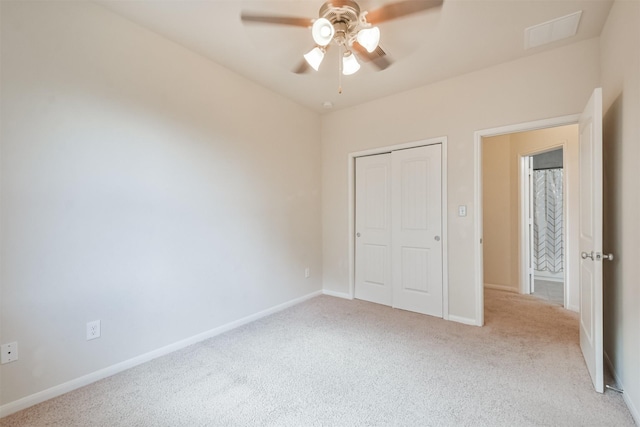 unfurnished bedroom with ceiling fan, light colored carpet, and a closet