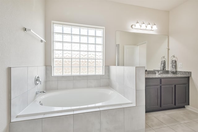 bathroom featuring vanity, tile patterned flooring, and tiled bath