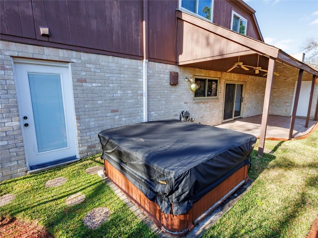 view of patio featuring ceiling fan and a covered hot tub