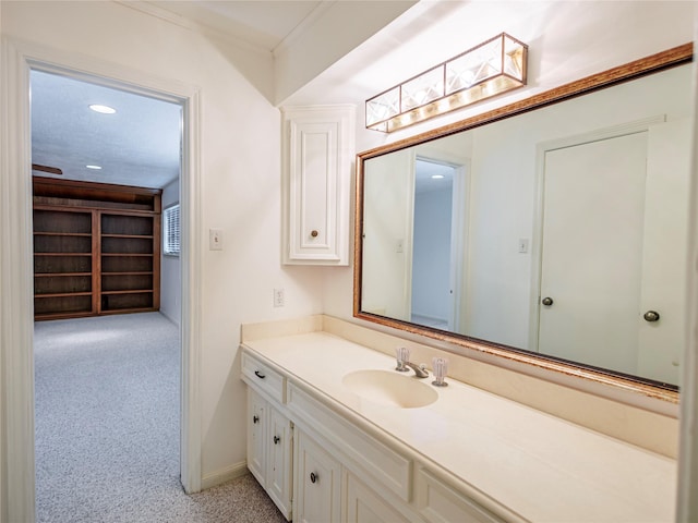 bathroom featuring vanity, crown molding, and a skylight