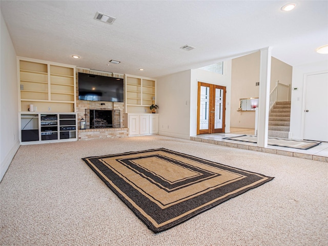 living room with built in features, french doors, a textured ceiling, and carpet flooring