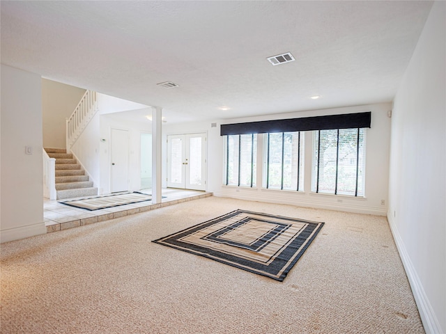 carpeted empty room featuring french doors