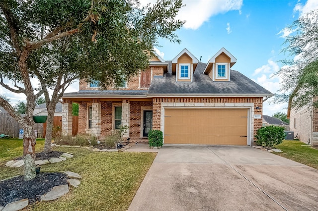 view of front of property with driveway, brick siding, an attached garage, cooling unit, and a front yard