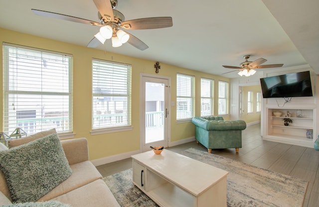 living room featuring a healthy amount of sunlight, ceiling fan, and built in shelves