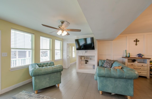 living room featuring ceiling fan and built in shelves