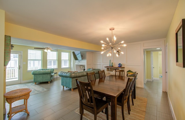 dining area featuring ceiling fan with notable chandelier