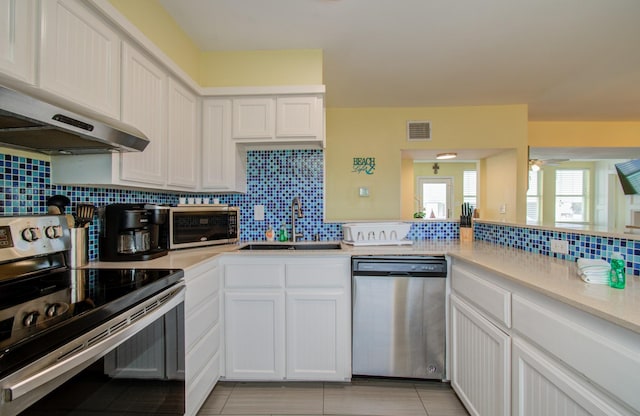 kitchen with sink, ceiling fan, appliances with stainless steel finishes, tasteful backsplash, and white cabinets