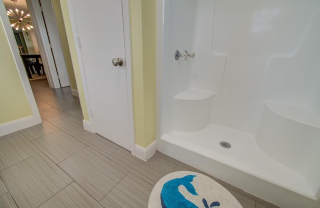 bathroom featuring an inviting chandelier and a shower