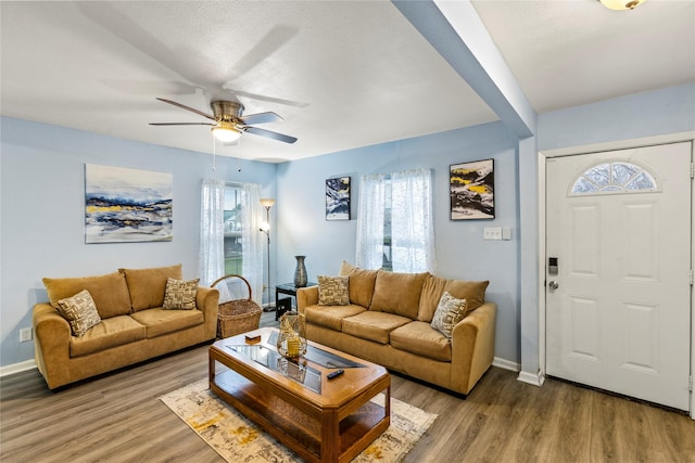 living room featuring wood-type flooring and ceiling fan