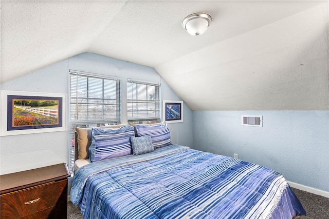 bedroom featuring lofted ceiling, carpet flooring, and a textured ceiling