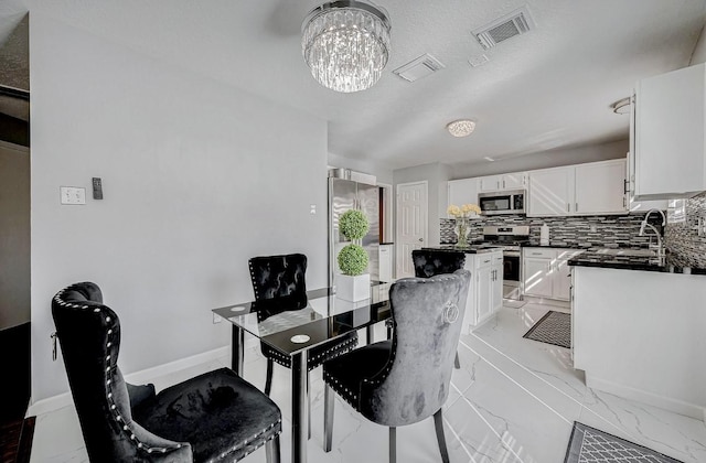 dining space with marble finish floor, visible vents, a chandelier, and baseboards