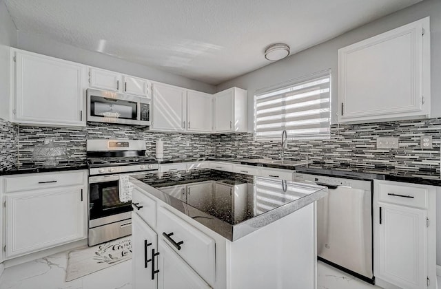 kitchen with backsplash, white cabinets, marble finish floor, stainless steel appliances, and a sink