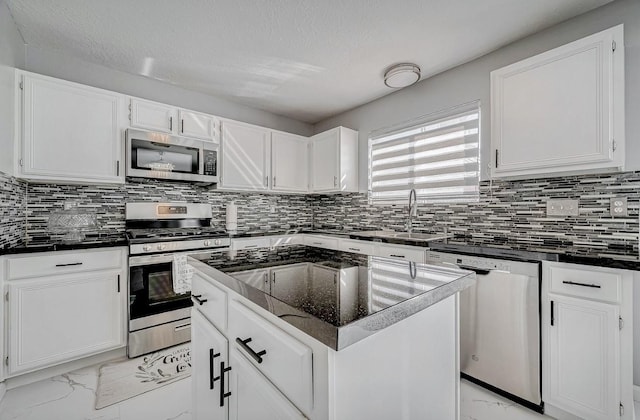 kitchen with marble finish floor, a sink, appliances with stainless steel finishes, and white cabinetry