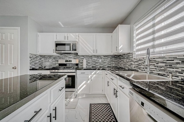 kitchen featuring tasteful backsplash, white cabinets, a sink, stainless steel appliances, and marble finish floor