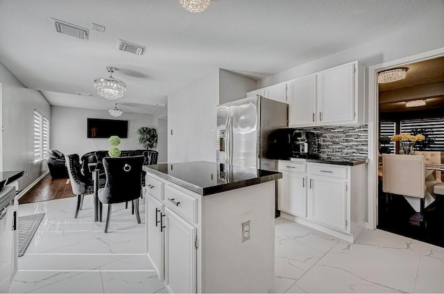 kitchen with dark countertops, visible vents, and marble finish floor