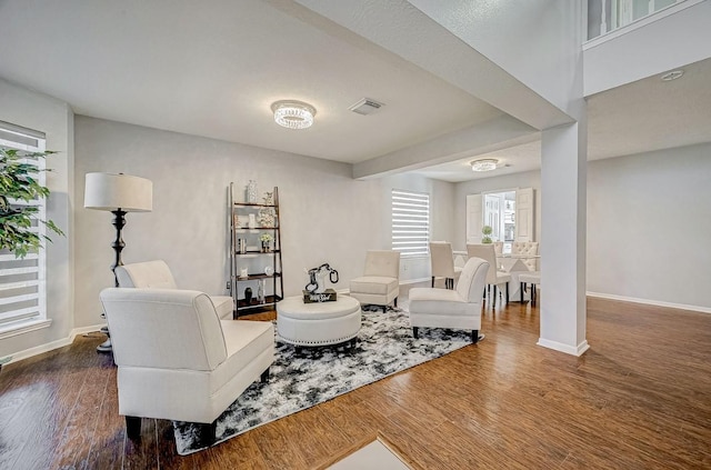 living room with wood finished floors, visible vents, and baseboards