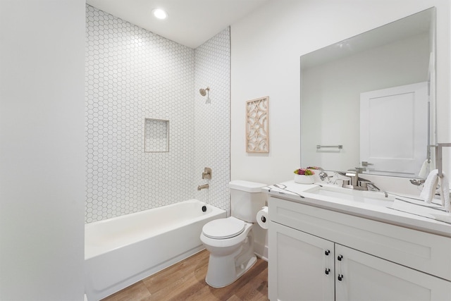 full bathroom featuring tiled shower / bath, hardwood / wood-style floors, vanity, and toilet