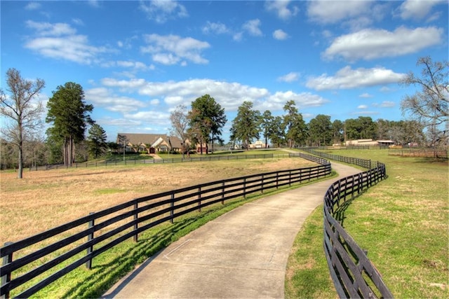 view of community with a rural view and a lawn