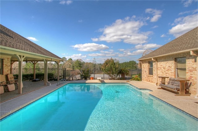 view of pool with a diving board and a patio