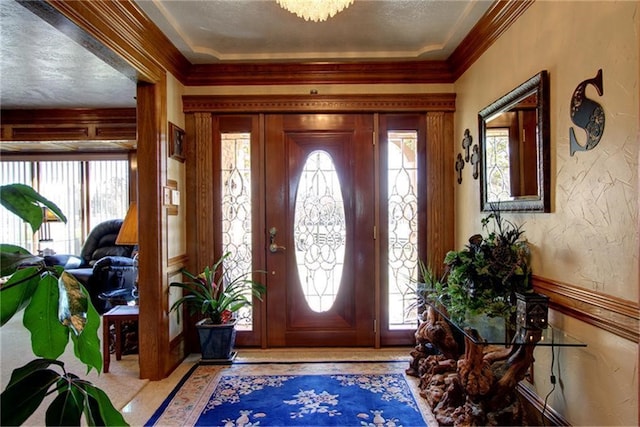 entryway featuring ornamental molding and a textured ceiling