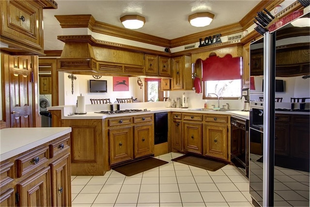 kitchen featuring washer / dryer, black dishwasher, sink, stainless steel gas cooktop, and kitchen peninsula