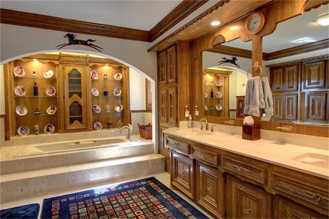 bathroom with ornamental molding, vanity, and tiled tub