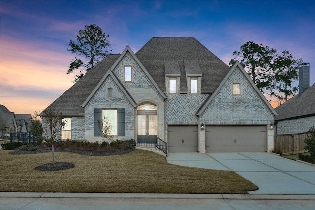 view of front of home featuring brick siding, roof with shingles, concrete driveway, a garage, and a front lawn